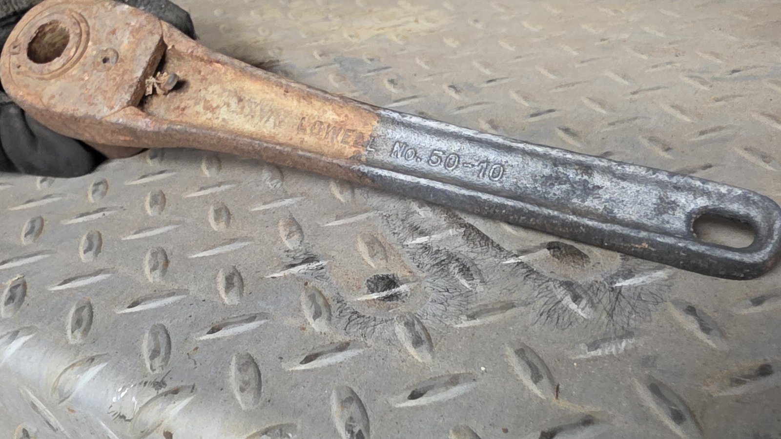 Wrench with a rusty head and a cleaned handle